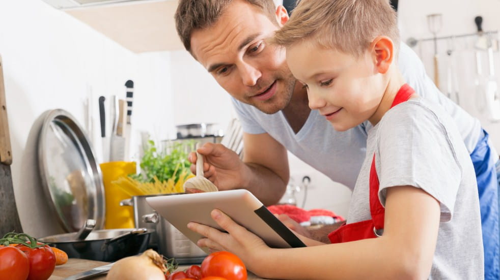 Father and son doing virtual cooking class together